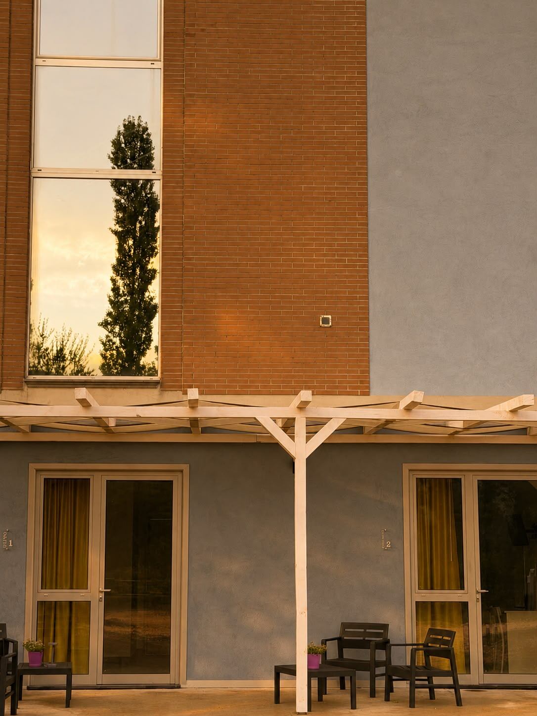 La facciata della struttura al tramonto, con le porte delle camere