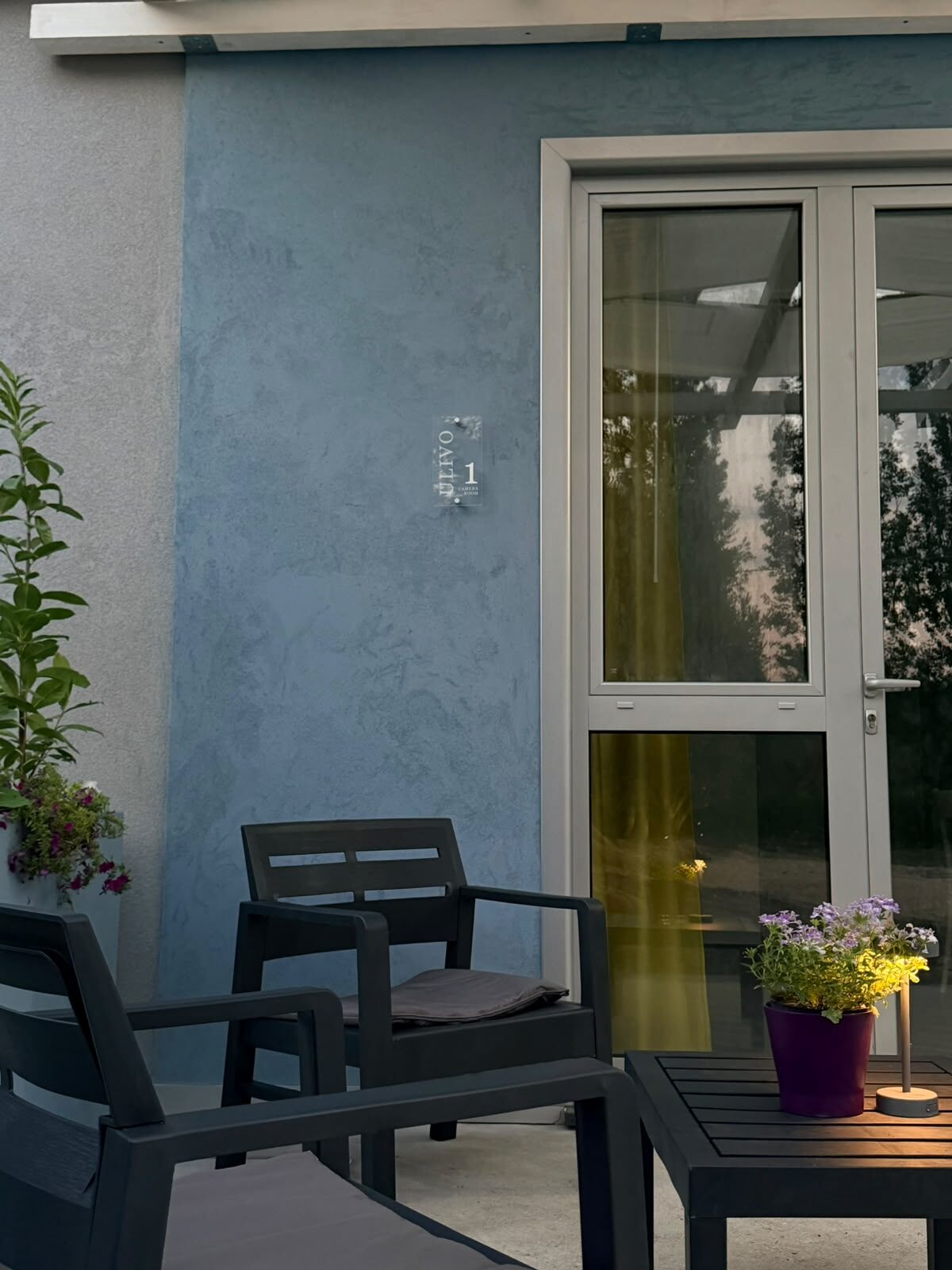 La terrazza serale con sedute e fiori davanti alla Camera Ulivo