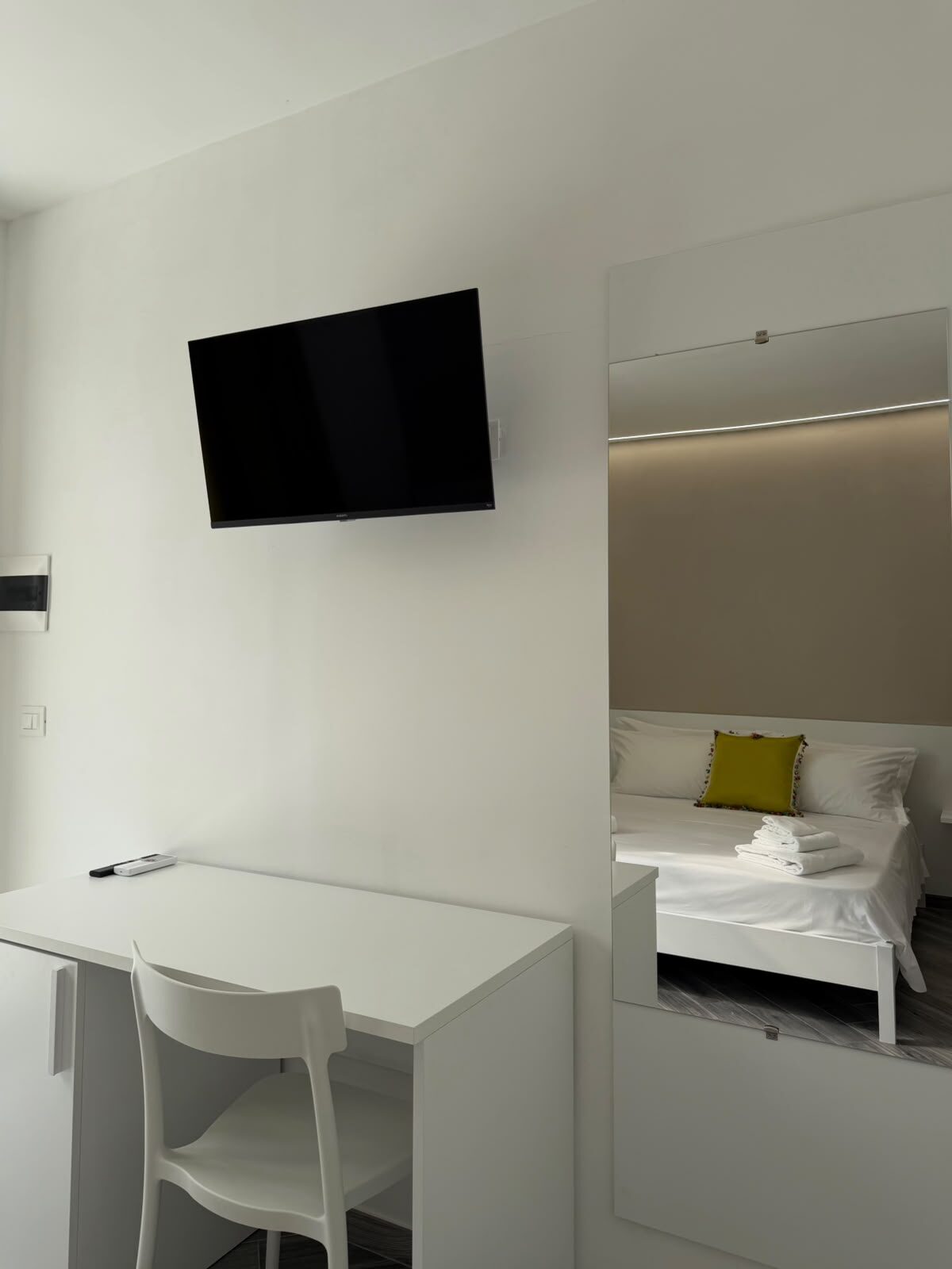 Camera Mirto — scrivania con Smart TV a parete e specchio che riflette il letto matrimoniale